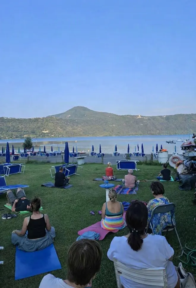 Partecipanti alla pratica di mindfulness sulla riva del lago di Castel Gandolfo